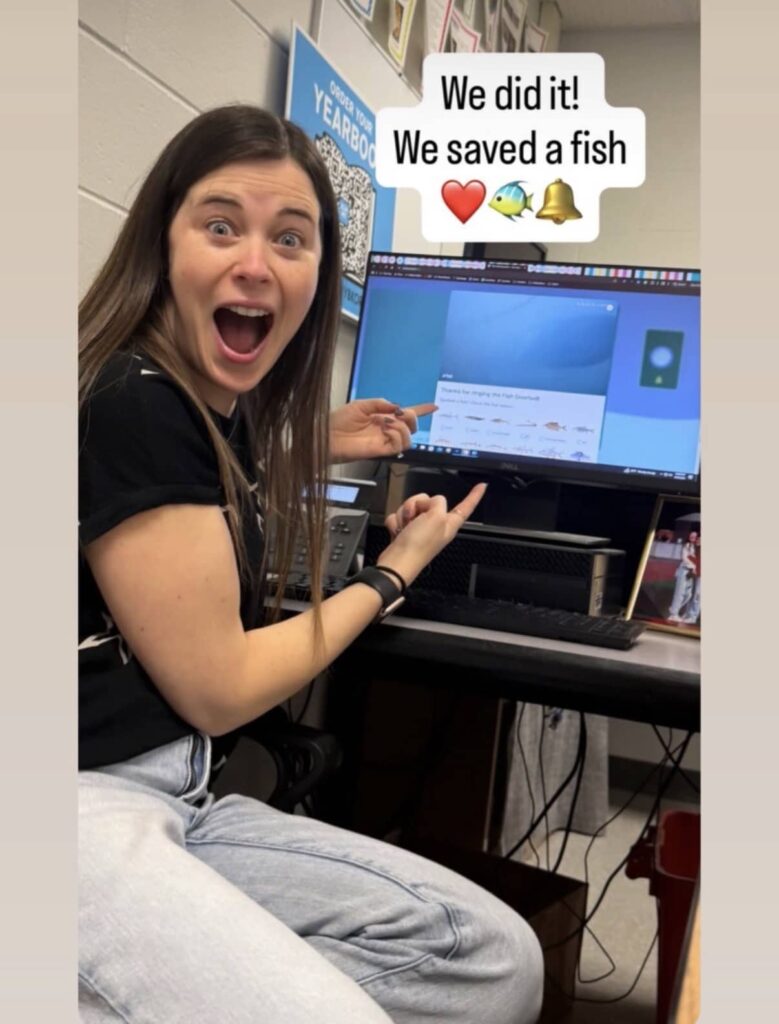 A Fish Doorbell fan points at a computer screen and smiles at the camera. The screen says: “We did it! We saved a fish.”