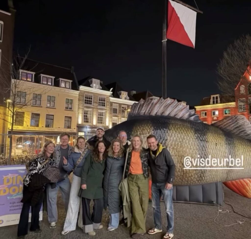 During a night out, nine people pose next to Barry, the inflatable perch.
