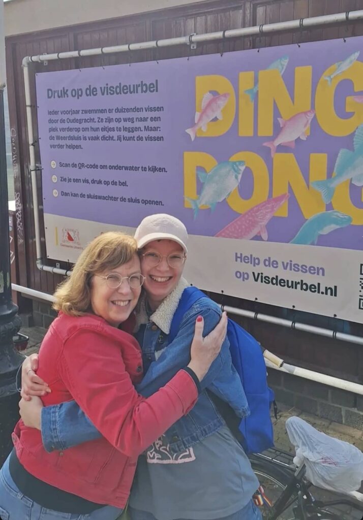 wo people hug beside the lock next to a Fish Doorbell banner.